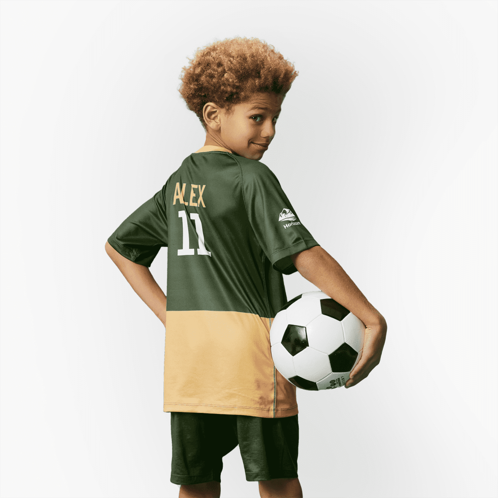 Child wearing sports top and holding football