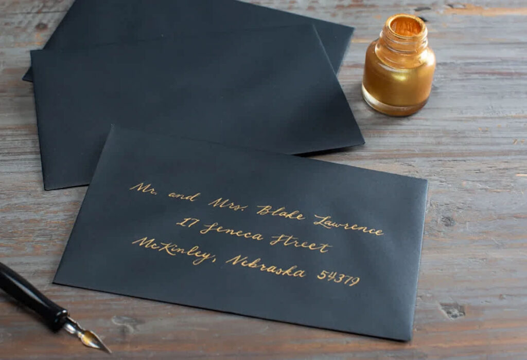 Beautifully handwritten address on a black envelope.