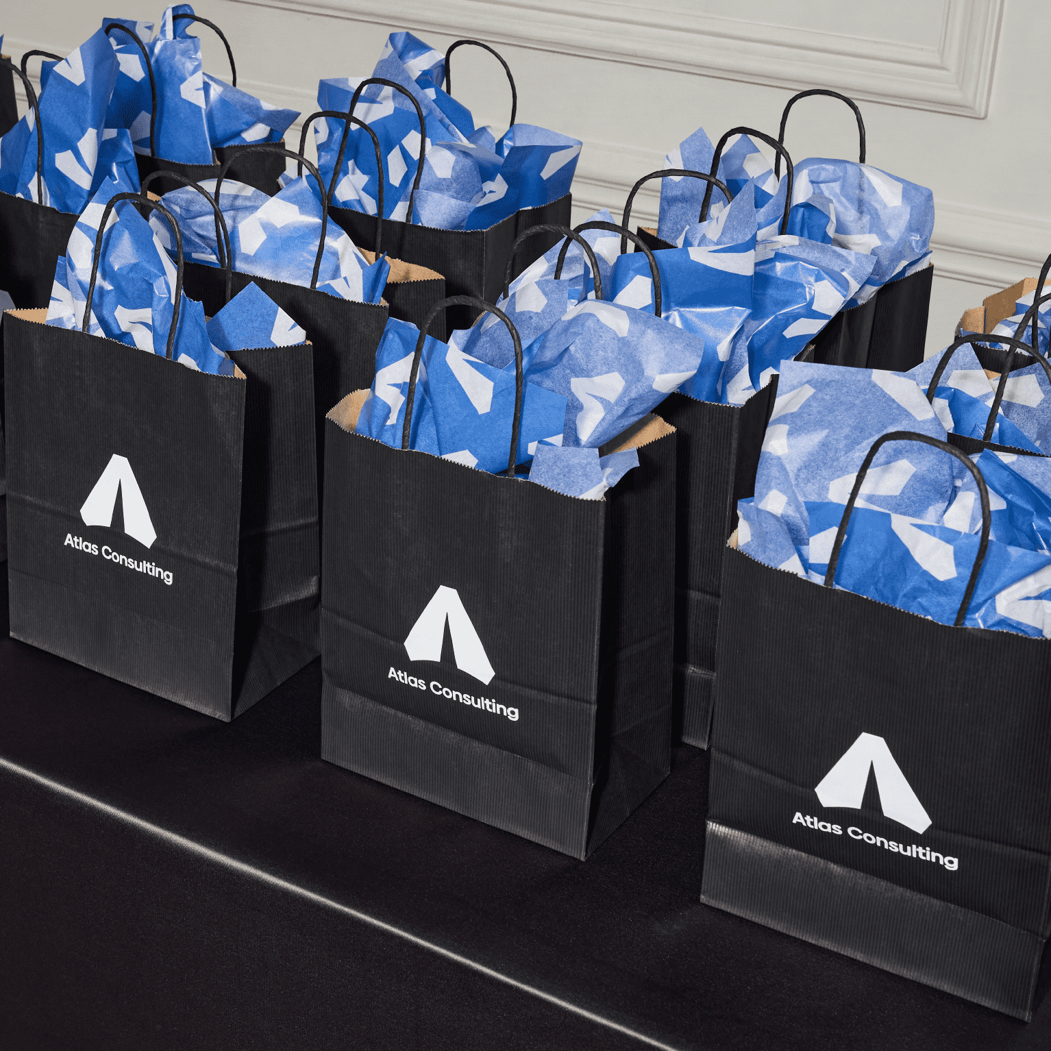 Branded event giveaway bags with custom tissue paper and logo printing arranged for a corporate event, trade show or promotional campaign.