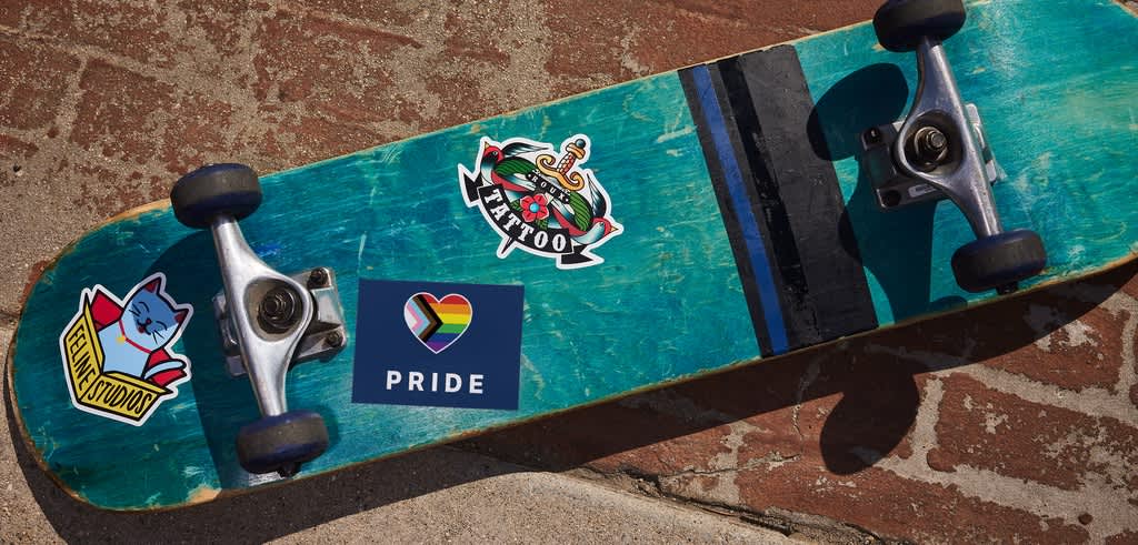 Skateboard deck with various custom stickers applied, showing how stickers are placed on real surfaces and remain visible through everyday use