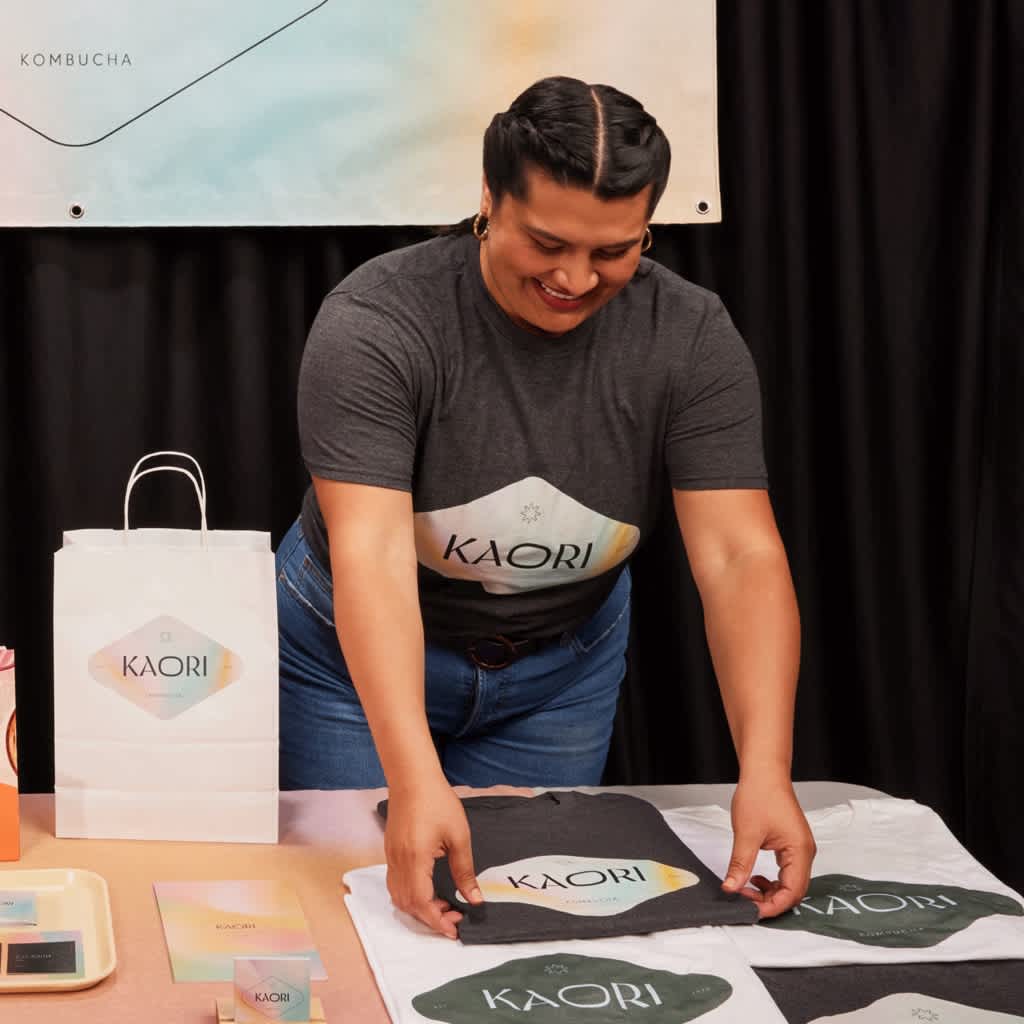 Kaori trade show booth with woman organizing t-shirts