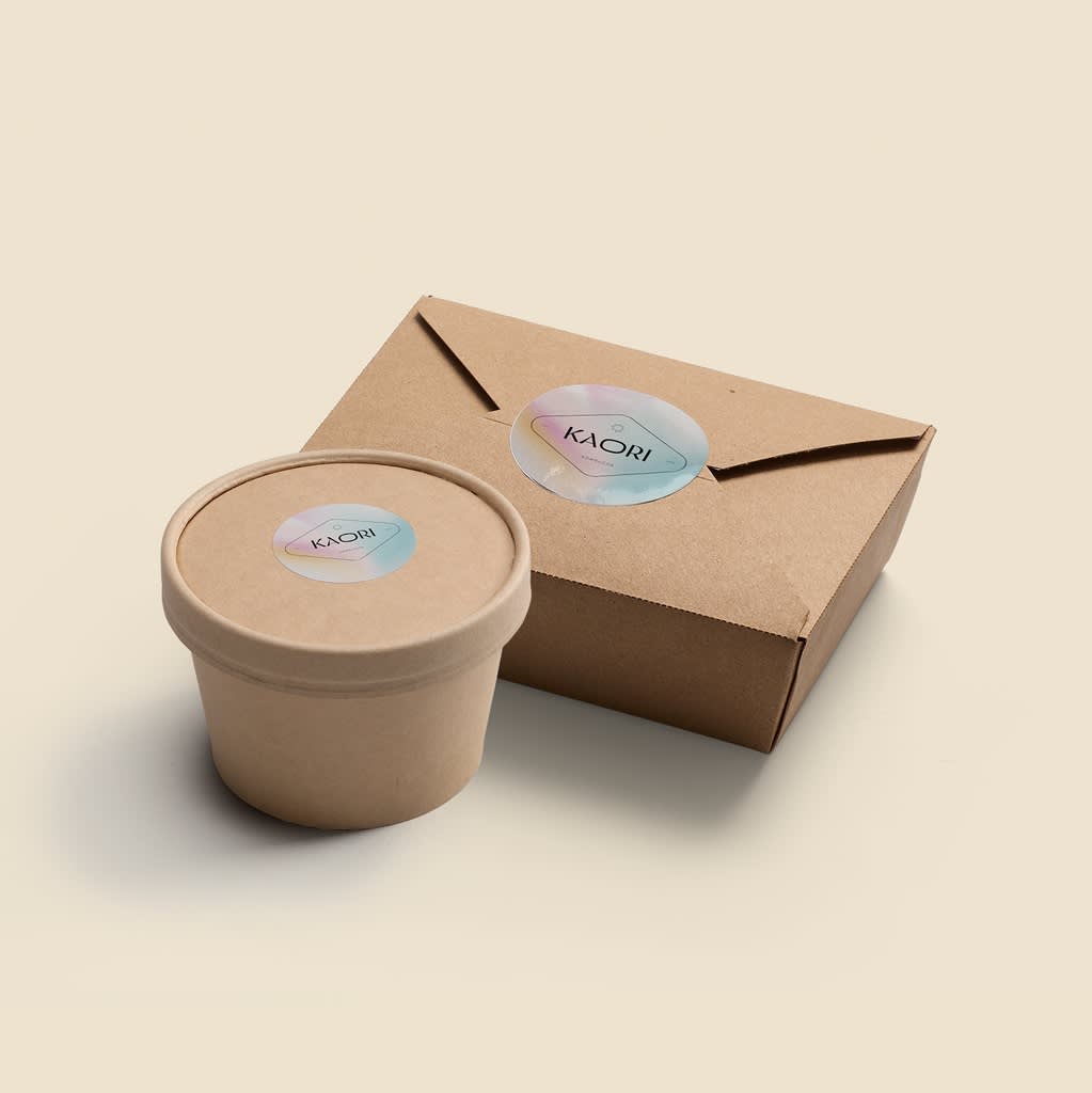 Kraft paper takeaway box and matching food container with lid, both sealed with branded stickers.