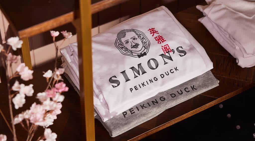 A folded white T-shirt with black illustrated branding for a Chinese restaurant.