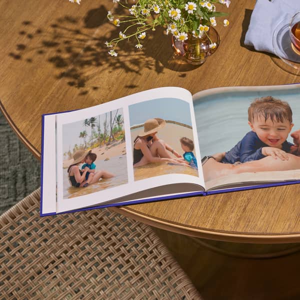 A personalized photo book with family photos laying flat open on a table