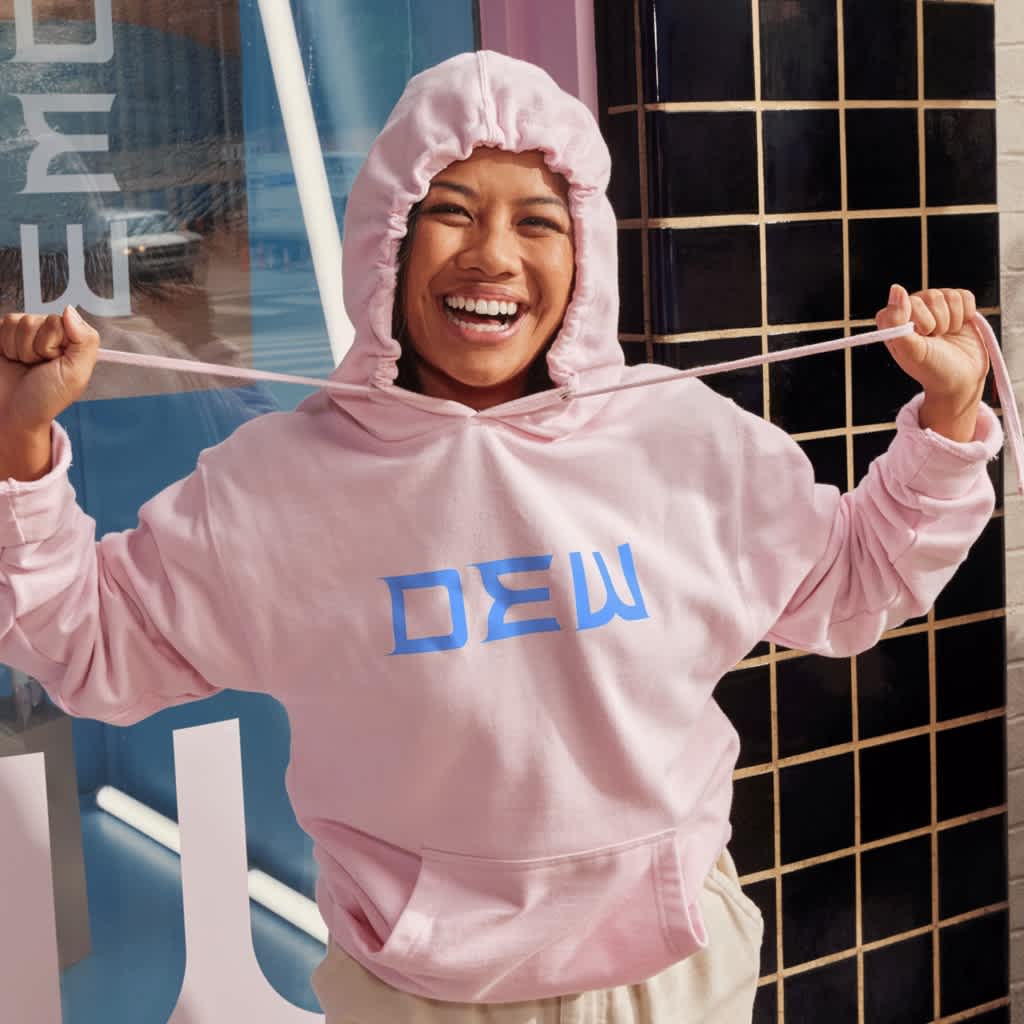 Employee wearing a pink branded hoodie with a blue brand logo.