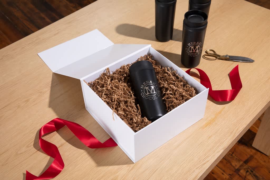 Black tumbler with holiday gift packaging for client gifts.