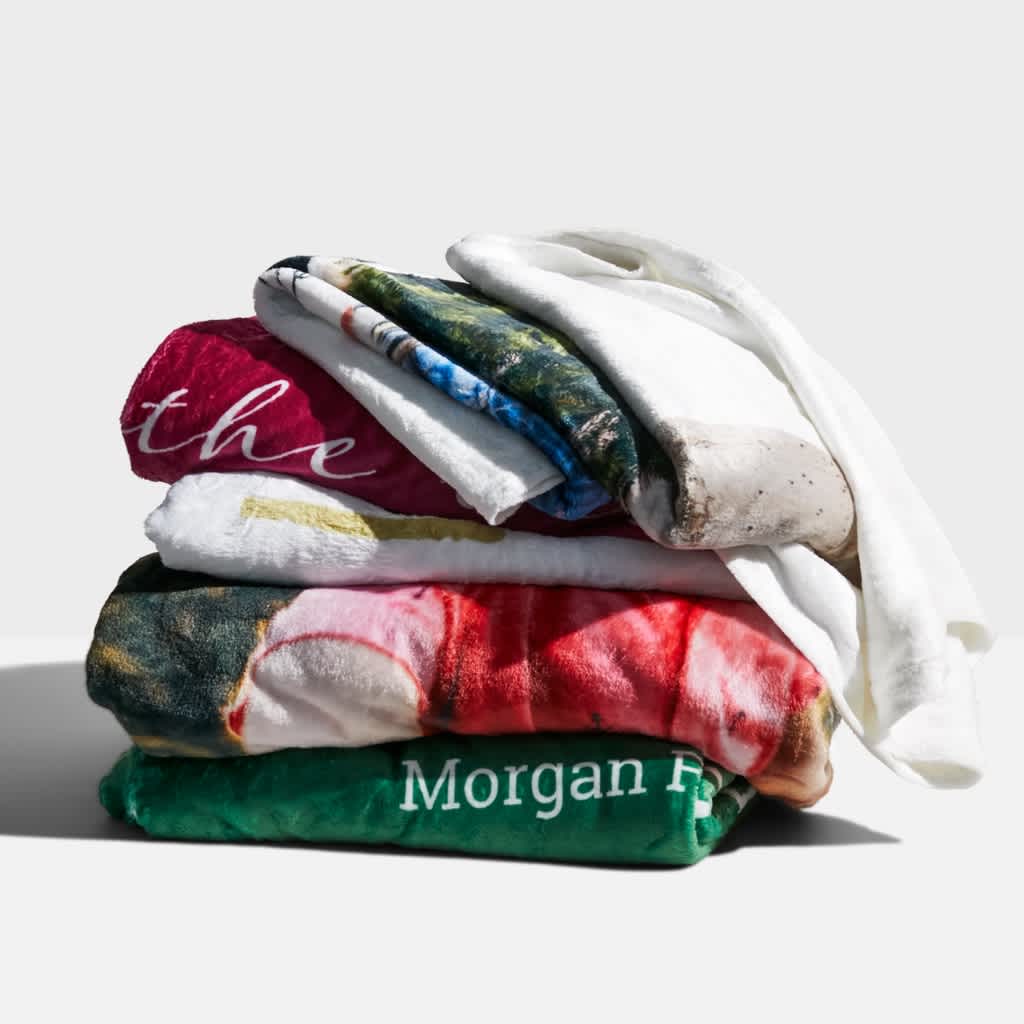 Pile of custom fleece blankets given as Christmas gifts, White Elephant gift ideas.