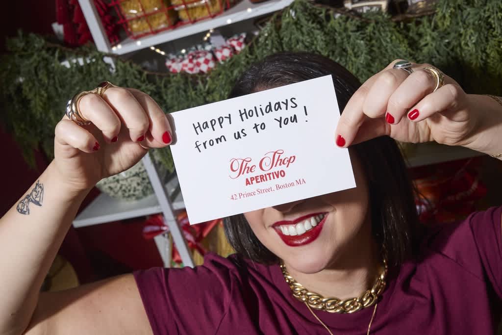 A woman holding a hand-written holiday greetings note.