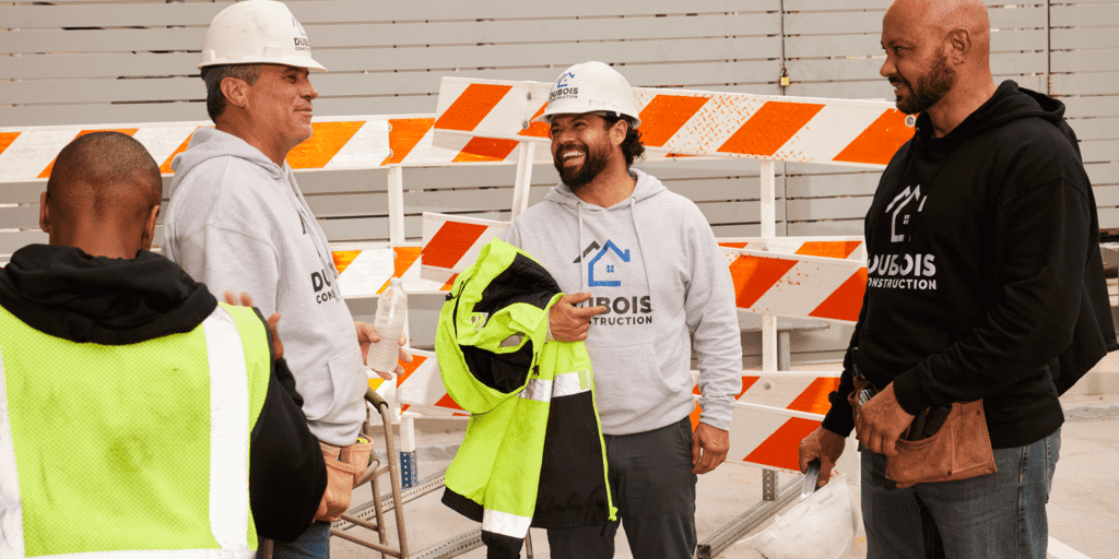 Construction workers wearing branded hoodies as workwear on a construction site