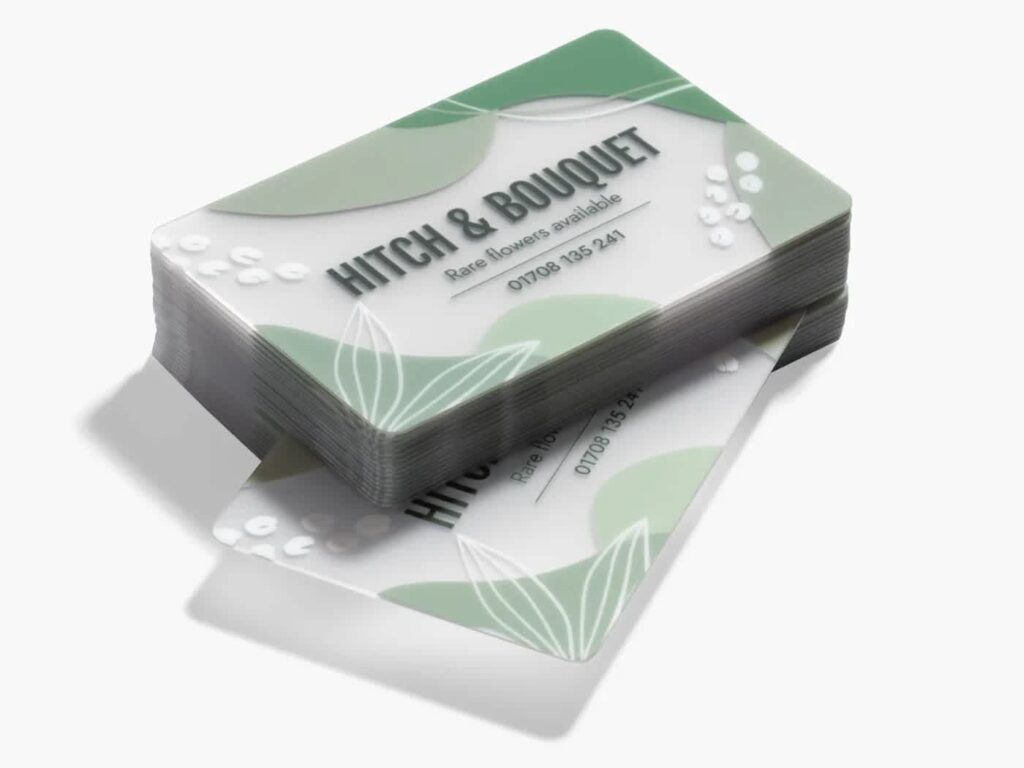 Stack of frosted plastic business cards with a green floral design for a flower business.