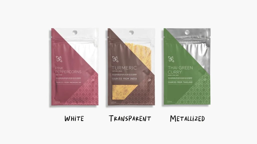 Three custom spice pouches in white, transparent and metallized films, featuring pink peppercorns, turmeric and Thai green curry packaging.