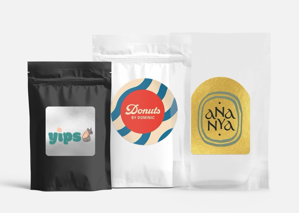 Three branded stand-up pouches in black, white and clear materials, featuring resealable zippers and custom labels.