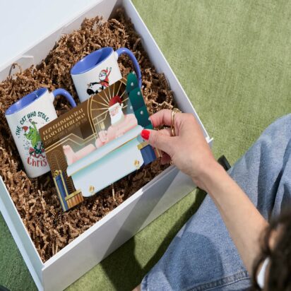 Hand opening gift basket to see Christmas card