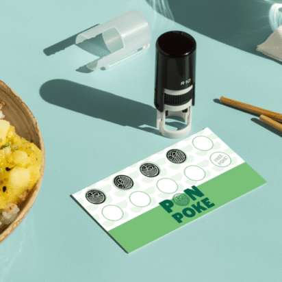 Custom stamp on a loyalty card beside a fresh poke bowl on a mint green background