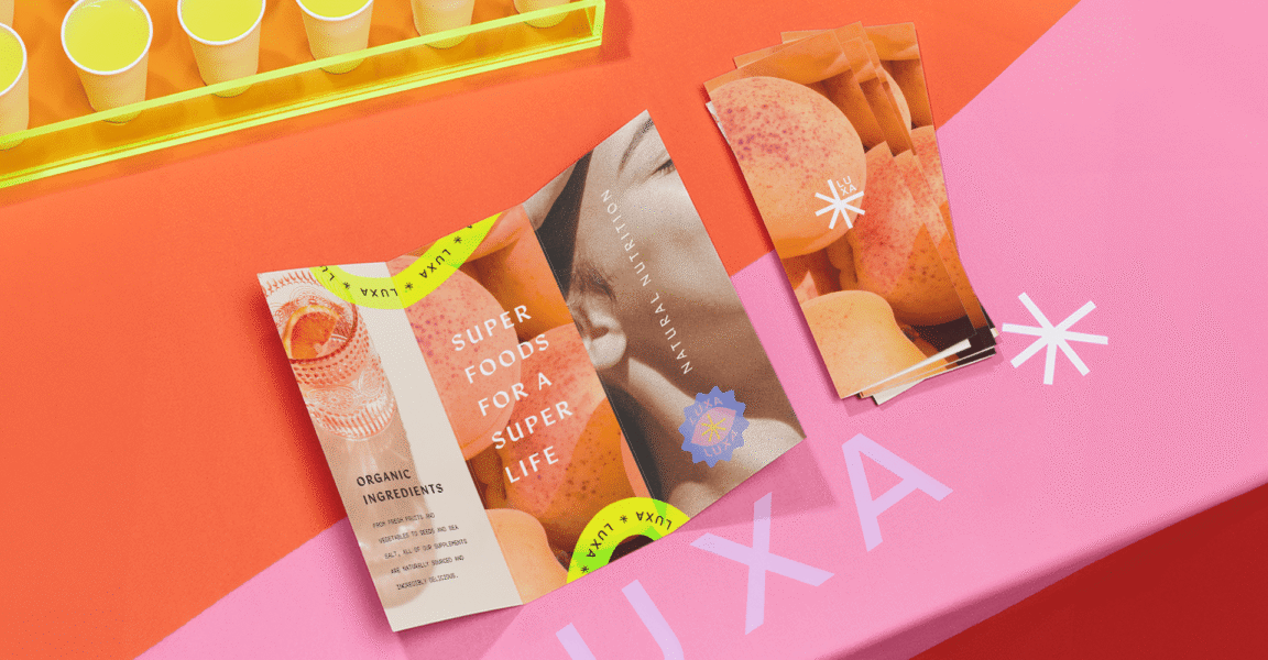 Colorful brochure and flyers on display table with bold images and typography, showcasing modern graphic design layout