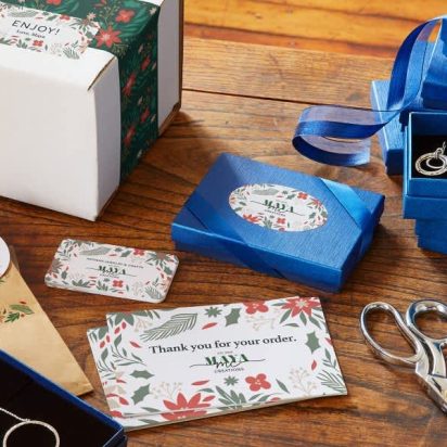 An assortment of branded packaging, stickers, postcards and boxes for a small business.