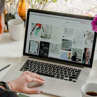 A business owner reviews website designs on a laptop.