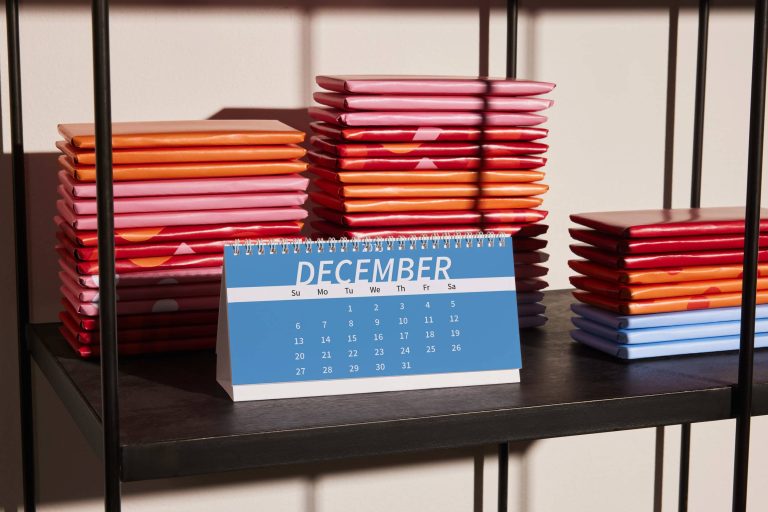 Small calendar on a shelf with notebooks