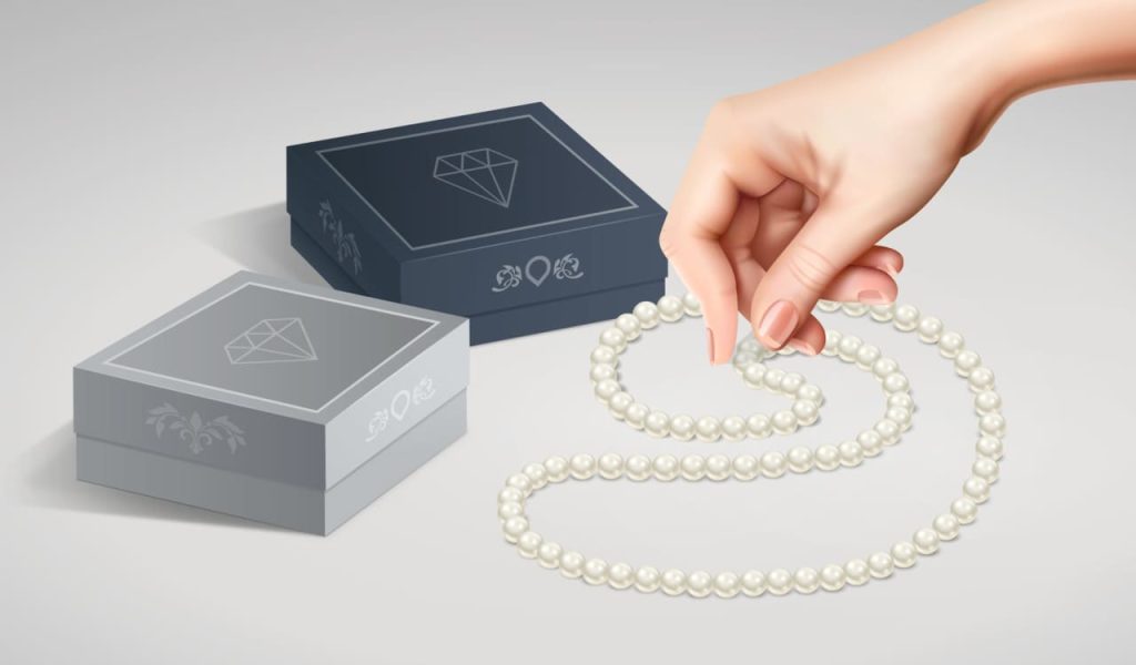 An example of jewelry packaging showing two boxes of different colors and a pearl necklace.