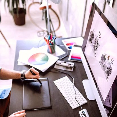 A person sitting at the computer look at their design