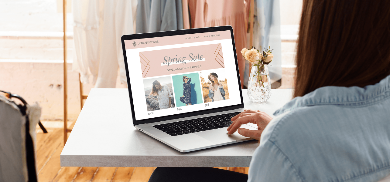 A woman looking out at her business website on a laptop
