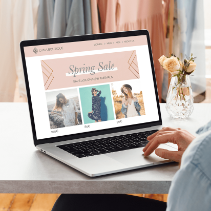 A woman looking out at her business website on a laptop