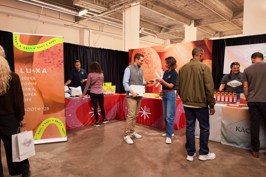 Trade Show Booth Ideas: attendees exploring colorful branded stands, promotional materials, and signage.