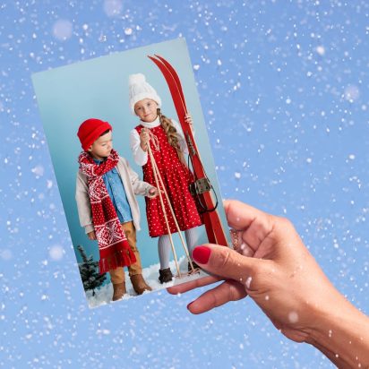 hand holds photo of kids dressed in ski clothes