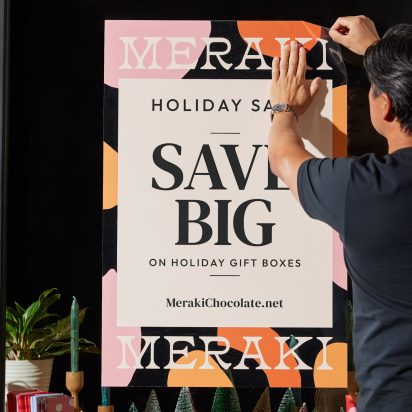 person puts up poster in store