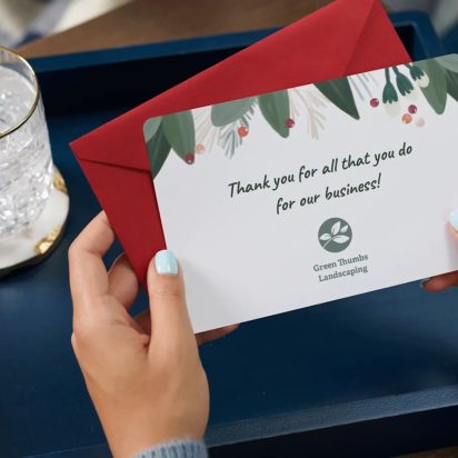 person holds up branded thank you card