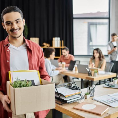 A colleague leaving the office with a box