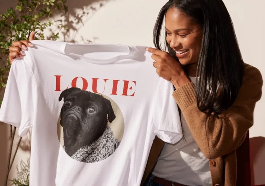 person holds up t-shirt design featuring "Louie" the bulldog