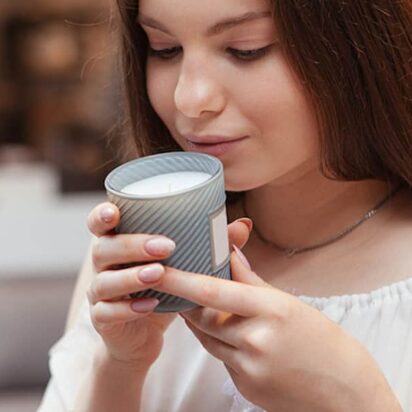 Woman smelling a candle in a candle shop