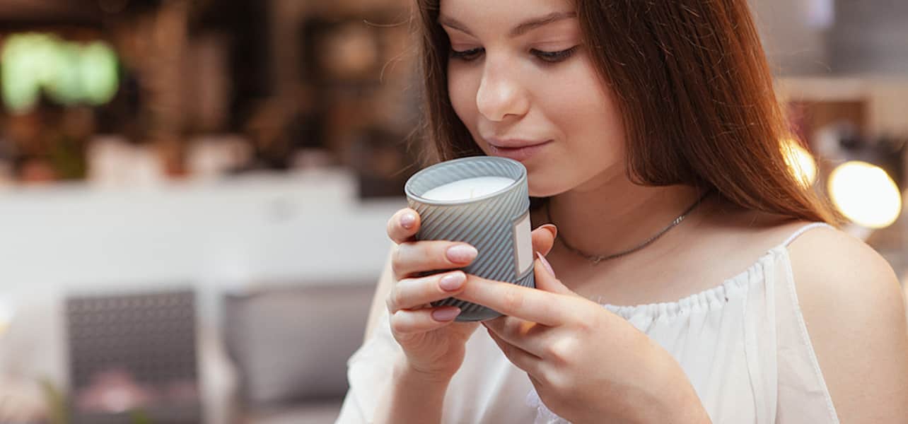 Woman smelling a candle in a candle shop