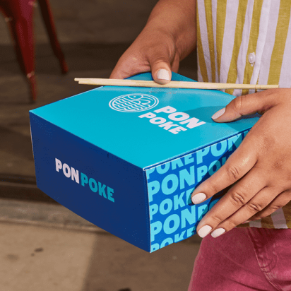 A blue and light blue PonPoke food packaging with wooden chopsticks, highlighting alliteration in the brand name.