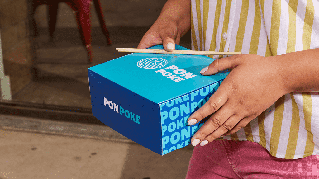 A blue and light blue PonPoke food packaging with wooden chopsticks, highlighting alliteration in the brand name.