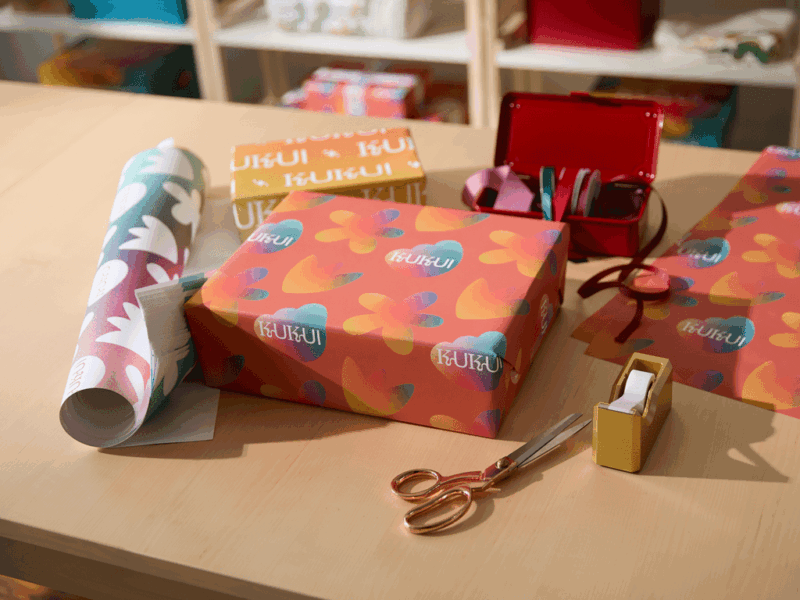 Wrapped gifts laying with colorful wrapping paper on a table.