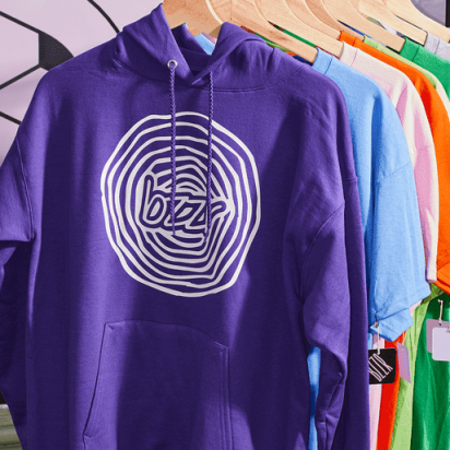 Colorful long-sleeve hoodies with custom logos hanging on a shop rack