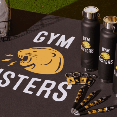 Gym Sisters branded gym set with mat, pens, keychains, water bottles, and cap.