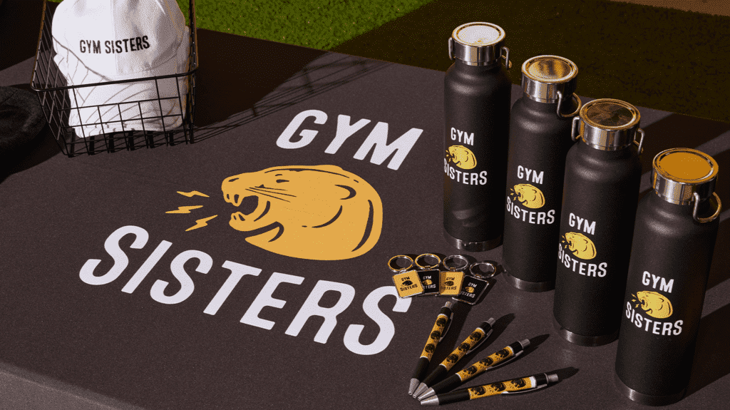 Gym Sisters branded gym set with mat, pens, keychains, water bottles, and cap.