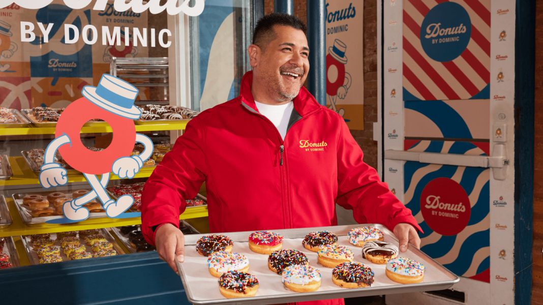 A donut shop employee wearing a branded uniform