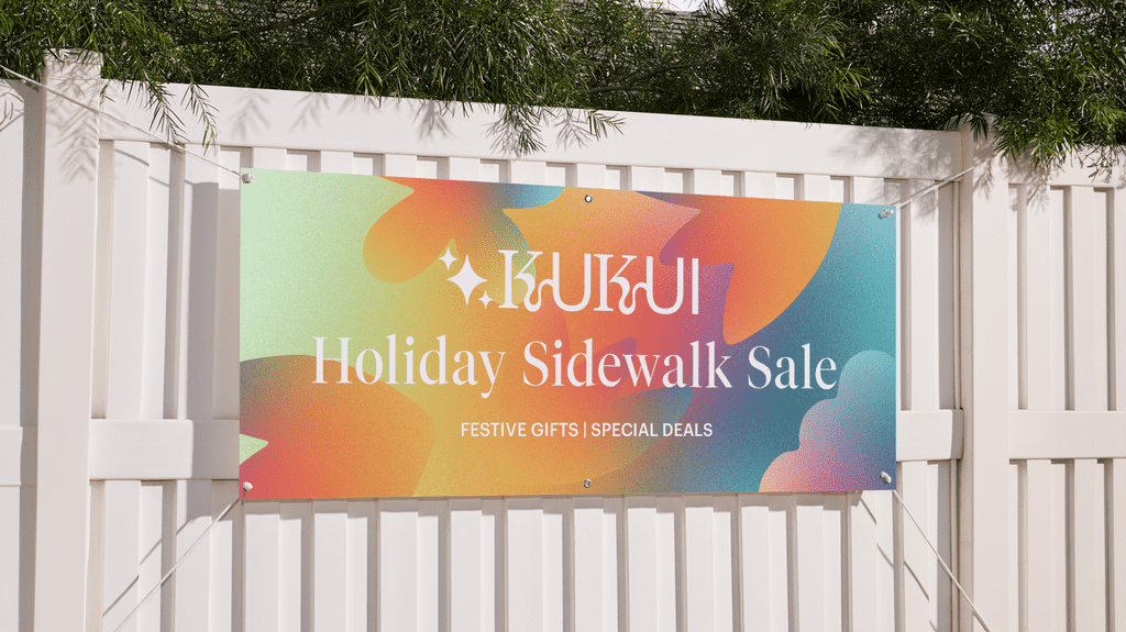 Colorful promotional banner hanging on a white fence, showcasing festive branding and message – example of banner materials in use.