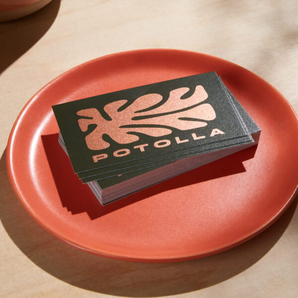 Red logo on a business card with a metallic finish