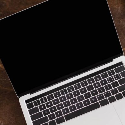 Above images of an open but dark screened laptop, on a desk beside a cup of coffee.