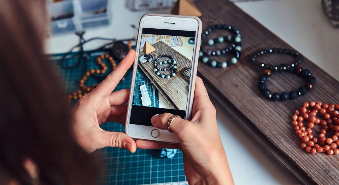 Small business owner photographing handmade bracelets for Instagram marketing.