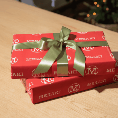 Two festively wrapped rectangles are stacked together on a table.