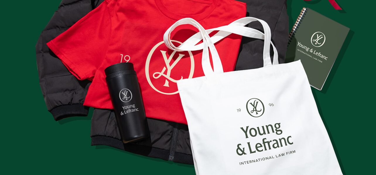 A top down image of a festively colored and branded tshirt, water bottle and tote bag