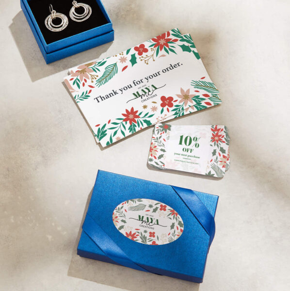 Example of branded packaging with elegant blue boxes and ribbon complete with custom stickers and promo materials in red, white and green
