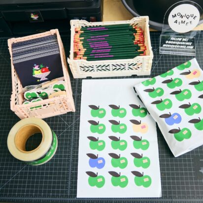 Colorful packaging materials, stickers, and stationery on a worktable, showing simple creative projects ideal for graphic design for beginners.