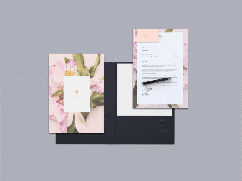 Hyper-Bloom graphic design trend showcased with sample of a stationary set, showing floral backgrounds and theme